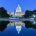 Night photo of the Capitol of the United States with a reflection in the pool in front.